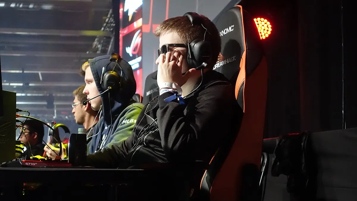 OG players in headsets at their computers on a tournament stage